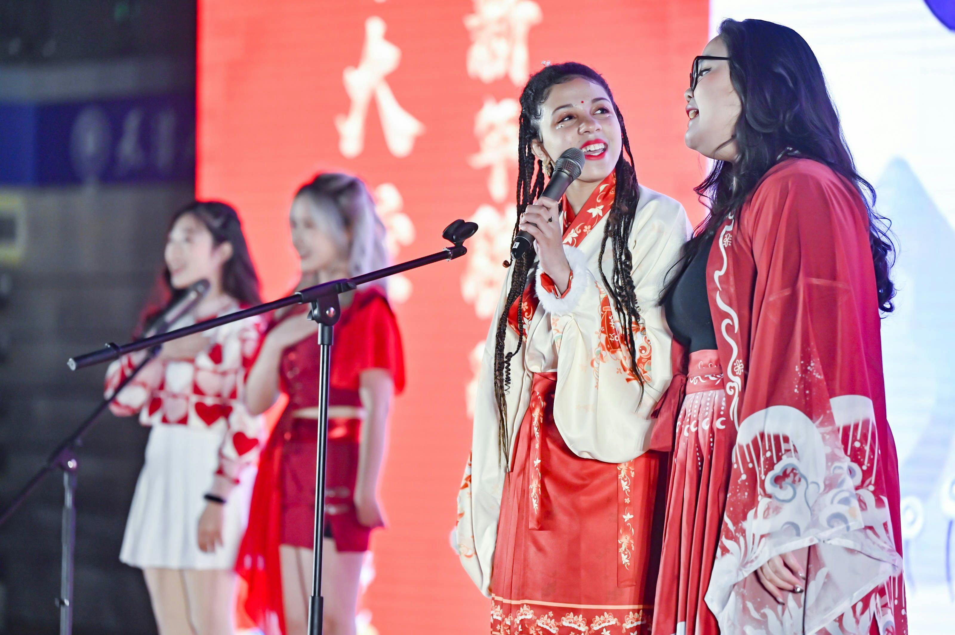 China Kultur, China Austausch, Schüleraustausch: Dieses Foto zeigt eine amerikanische Studentin in traditioneller chinesischer Kleidung, die mit anderen auf der Bühne steht