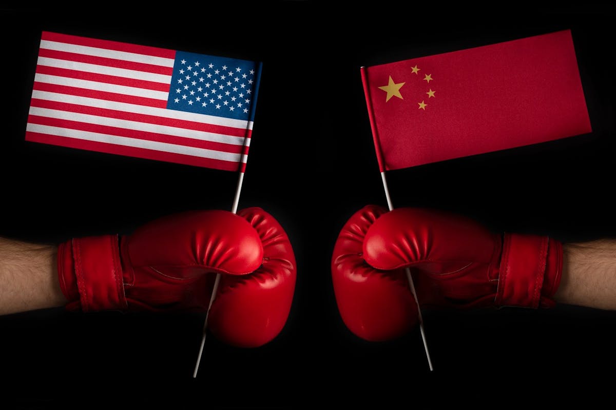 China Politik, China USA, Außenpolitik, Konflikt: Zwei Boxerhände mit USA- und China-Flaggen. 