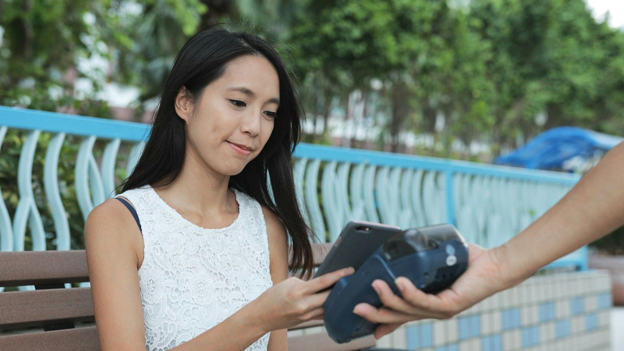 China News, Zahlungen, Bezahlen in China, Digitales Bezahlen, Zahlen, Zahlungsmittel: Frau benutzt Mobiltelefon zum Bezahlen