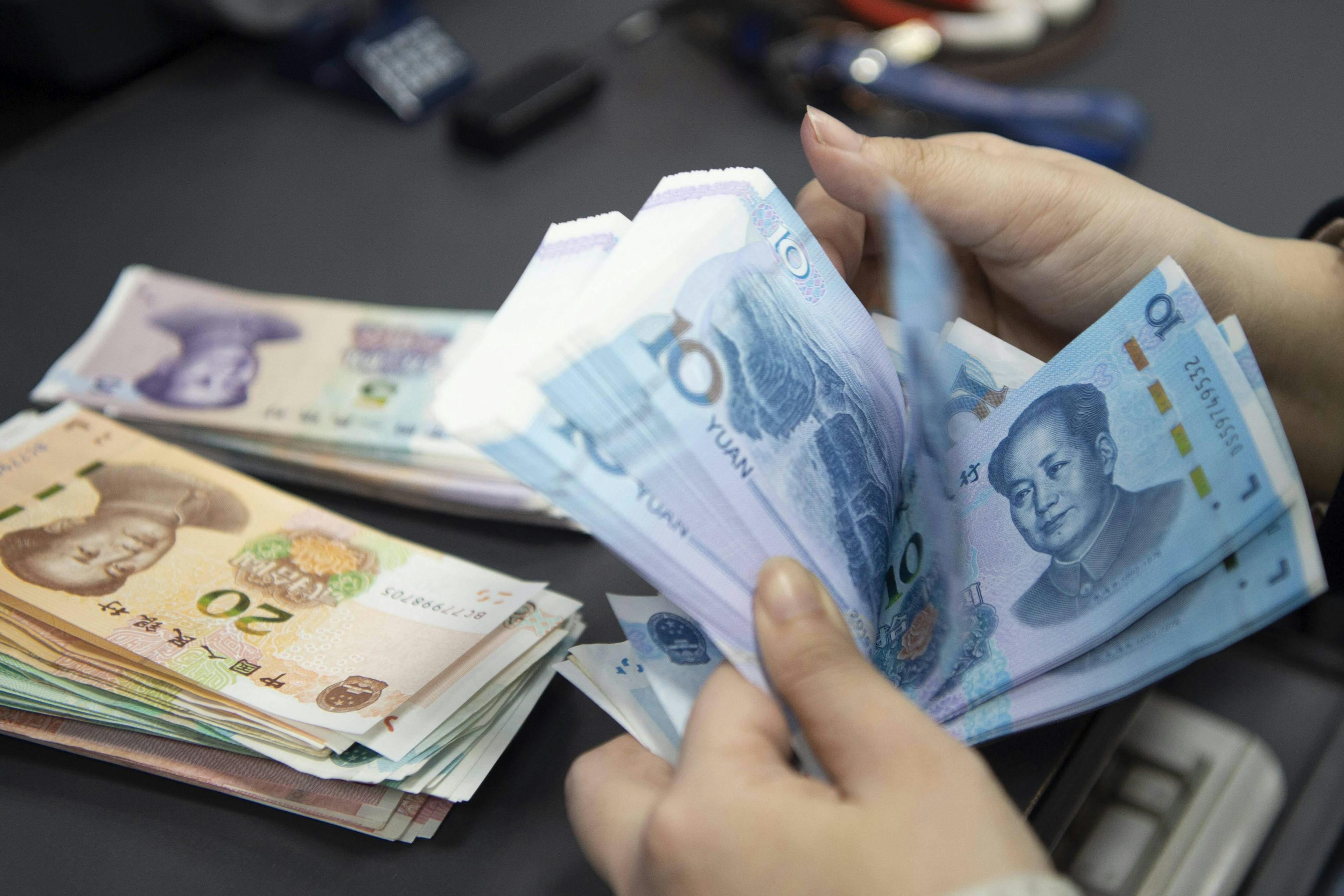 The People s Bank of China Announced A Cut in Reserve Requiremen A staff member in the personal finance business area of a bank is counting and arranging the RMB deposited by customers in the daily account in Haian, China
