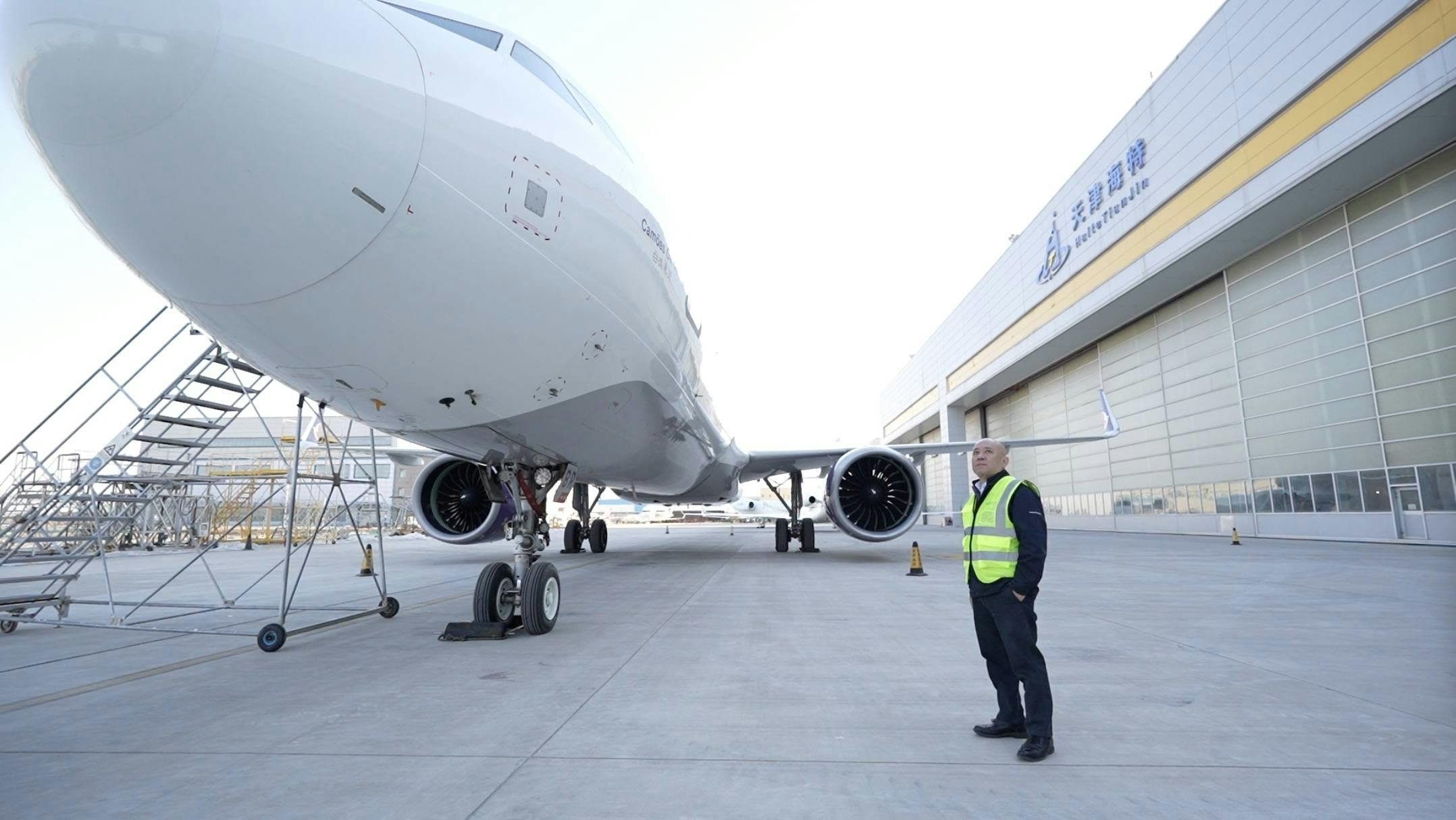 van Chin stands next to an airplane in Tianjin Haite Aircraft Engineering Co., Ltd. in north China s Tianjin Municipality, Jan. 15, 2024. TO GO WITH Across China: Singaporean businessman eyes further opportunities