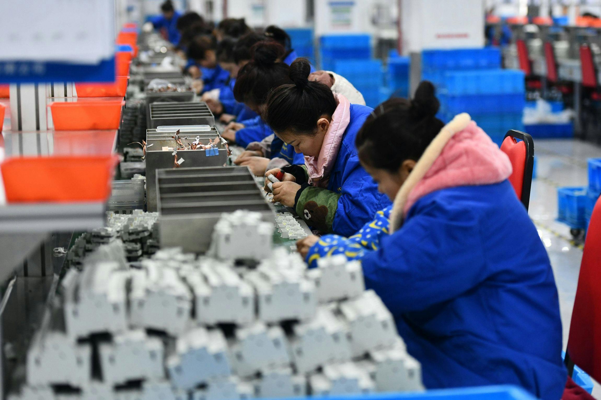PMI Arbeiter arbeiten in einer Werkstatt eines Elektrounternehmens in Fuyang, China, an einer Produktionslinie für Stromkreisunterbrecher