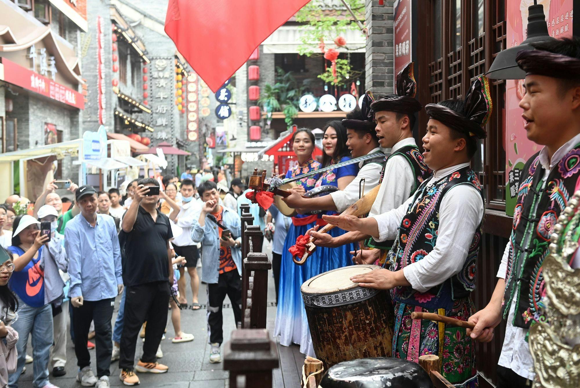 China Kultur, Feste, Volksfeste, Tourismus: Künstler treten bei der Feier des Sanyuesan-Festes in einer Gasse in Nanning, im südchinesischen autonomen Gebiet Guangxi Zhuang, auf. 