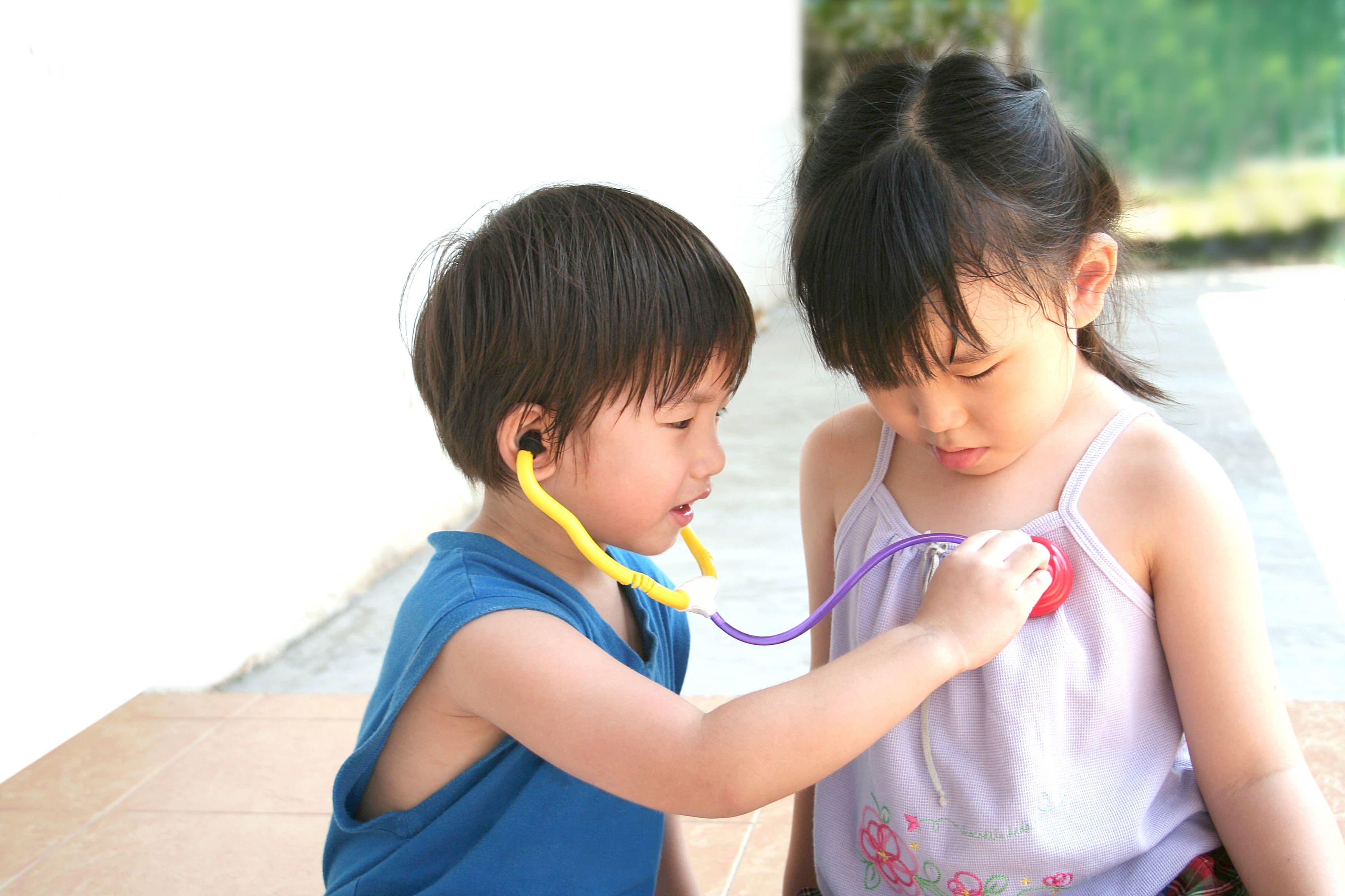 Gesundheitsvorsorge in China: Mädchen und Junge spielen mit einem Spielzeug-Stethoskop