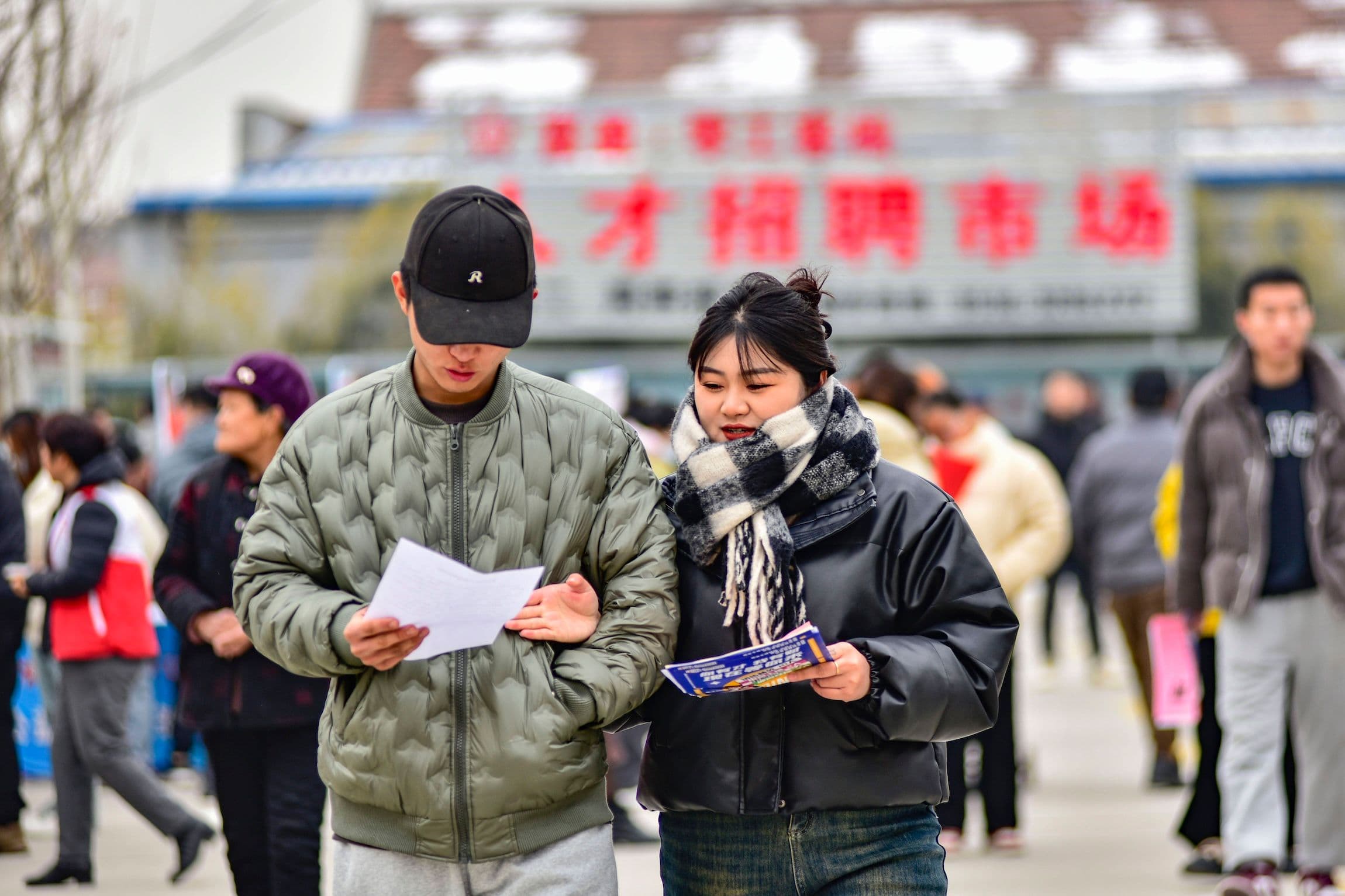 Arbeiten in China: junge Arbeitsuchende informieren sich über neu geschaffene Stellenangebote auf einer Jobmesse in China