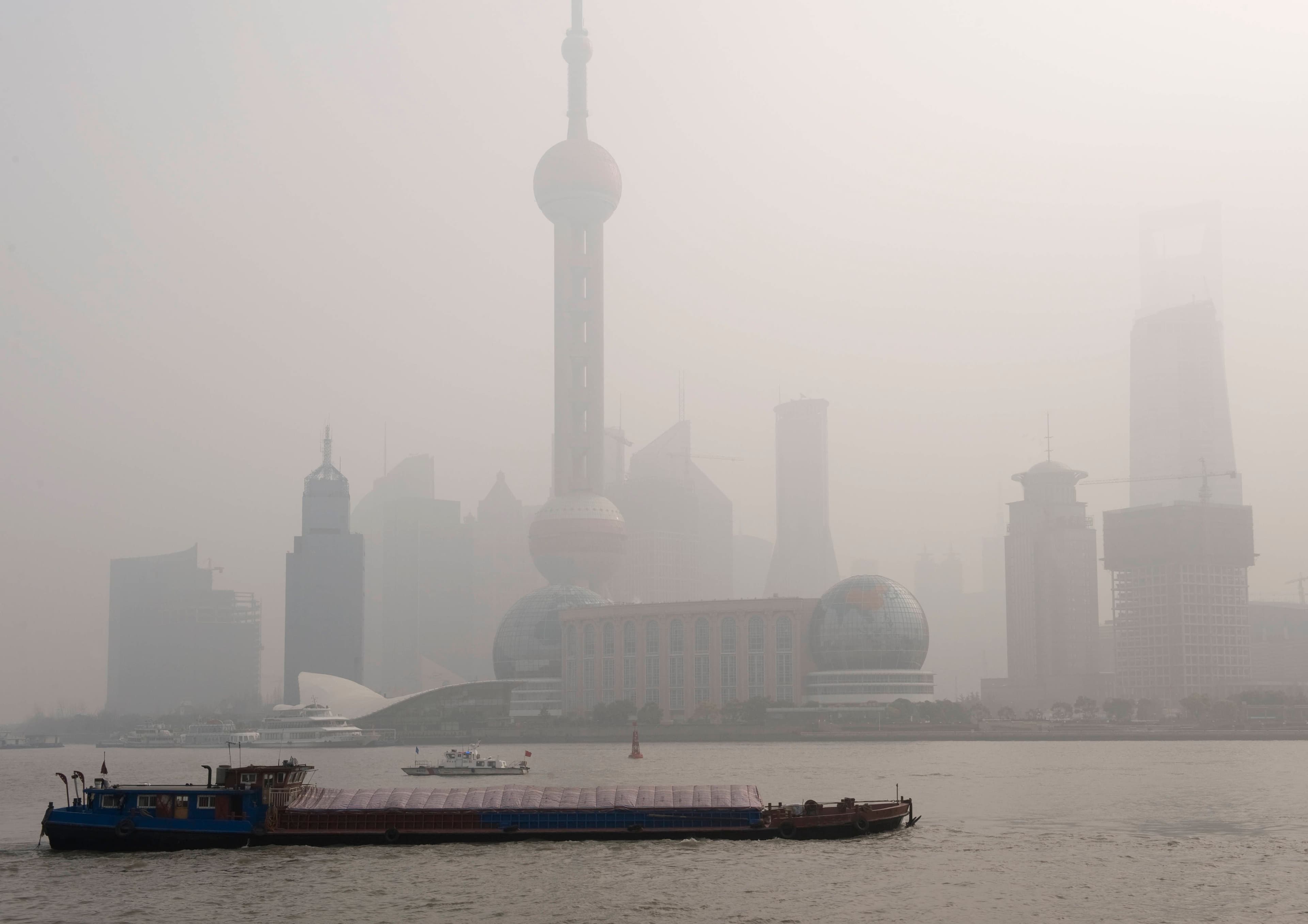 Luftverschmutzung über Shanghai, ein Lastkahn fährt vorbei