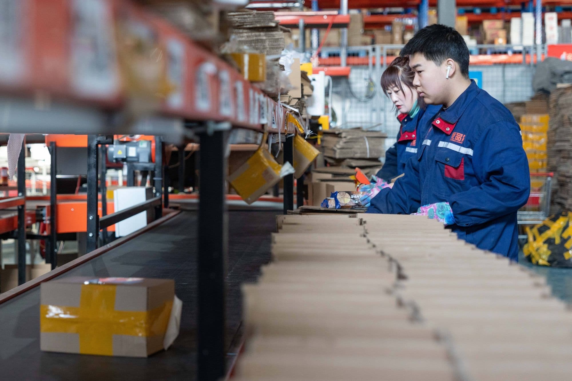 China Wirtschaftswachstum: Mitarbeiter sortieren Pakete an einem Förderband in einem Logistikzentrum in der Pilot-Freihandelszone Heihe Area of China (Heilongjiang) in Heihe in der nordostchinesischen Provinz Heilongjiang