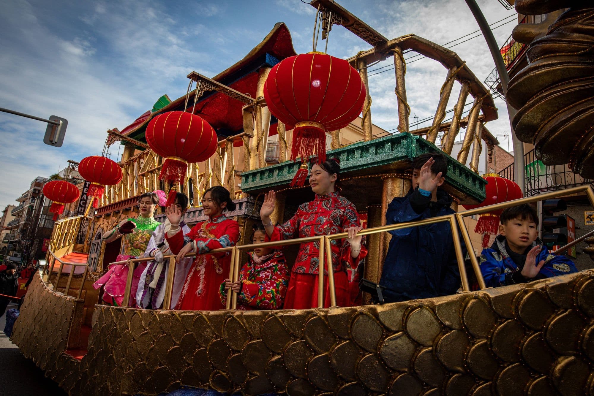 Eine Gruppe von Menschen paradiert auf einem Boot mit Arrangements während der chinesischen Neujahrsparade