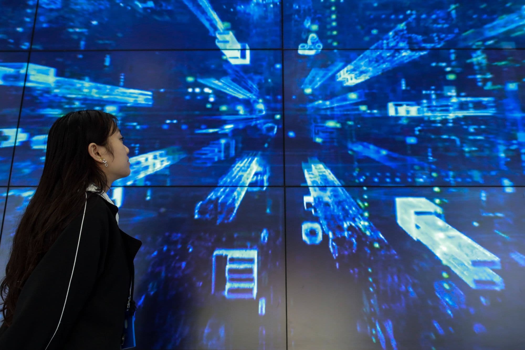 China Softwareindustrie, China Software, China Cloud, Cloudservices, Big Data, China Technologie: Ein Mitarbeiter geht an einem Bildschirm im Guizhou Information Park von China Telecom Cloud Computing vorbei