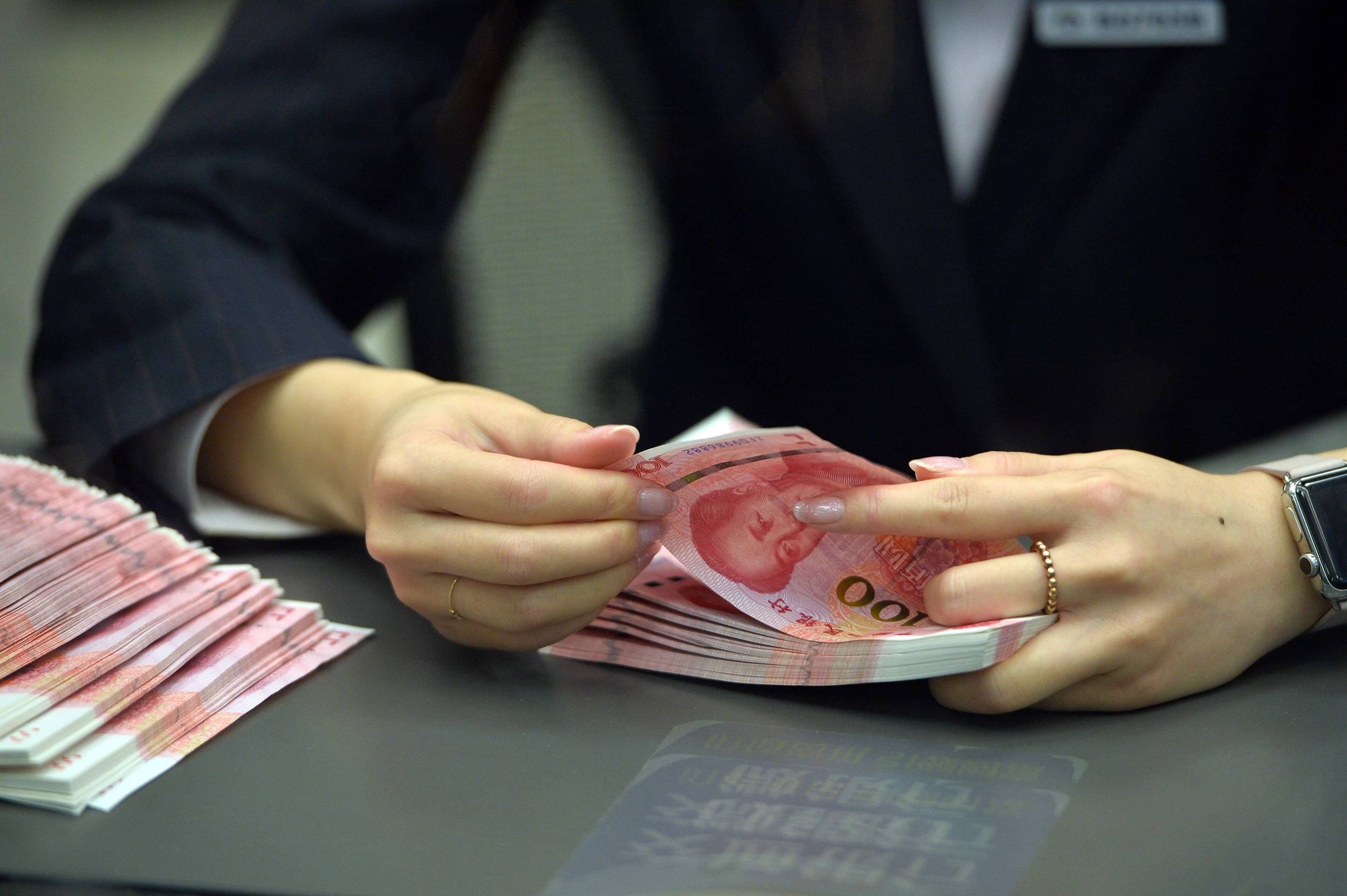 China Politik, china Wirtschaft, China Geld: Ein Bankangestellter zählt neue 100-Yuan-Banknoten in der Pekinger Filiale der Bank für Kommunikation in Peking, der Hauptstadt Chinas