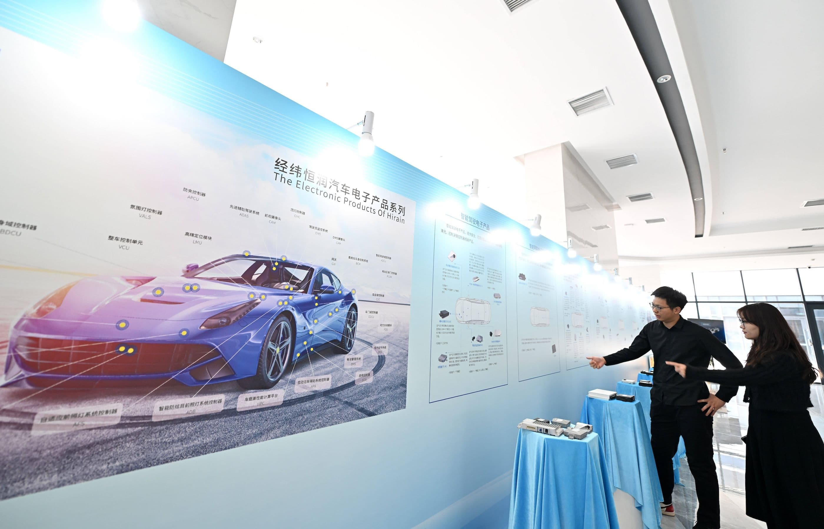 Mitarbeiter eines chinesischen Tech Unternehmens stehen vor der Anzeigetafel des Unternehmens im Tianjin R&D Center der Beijing Jingwei Hirain Technologies Co.