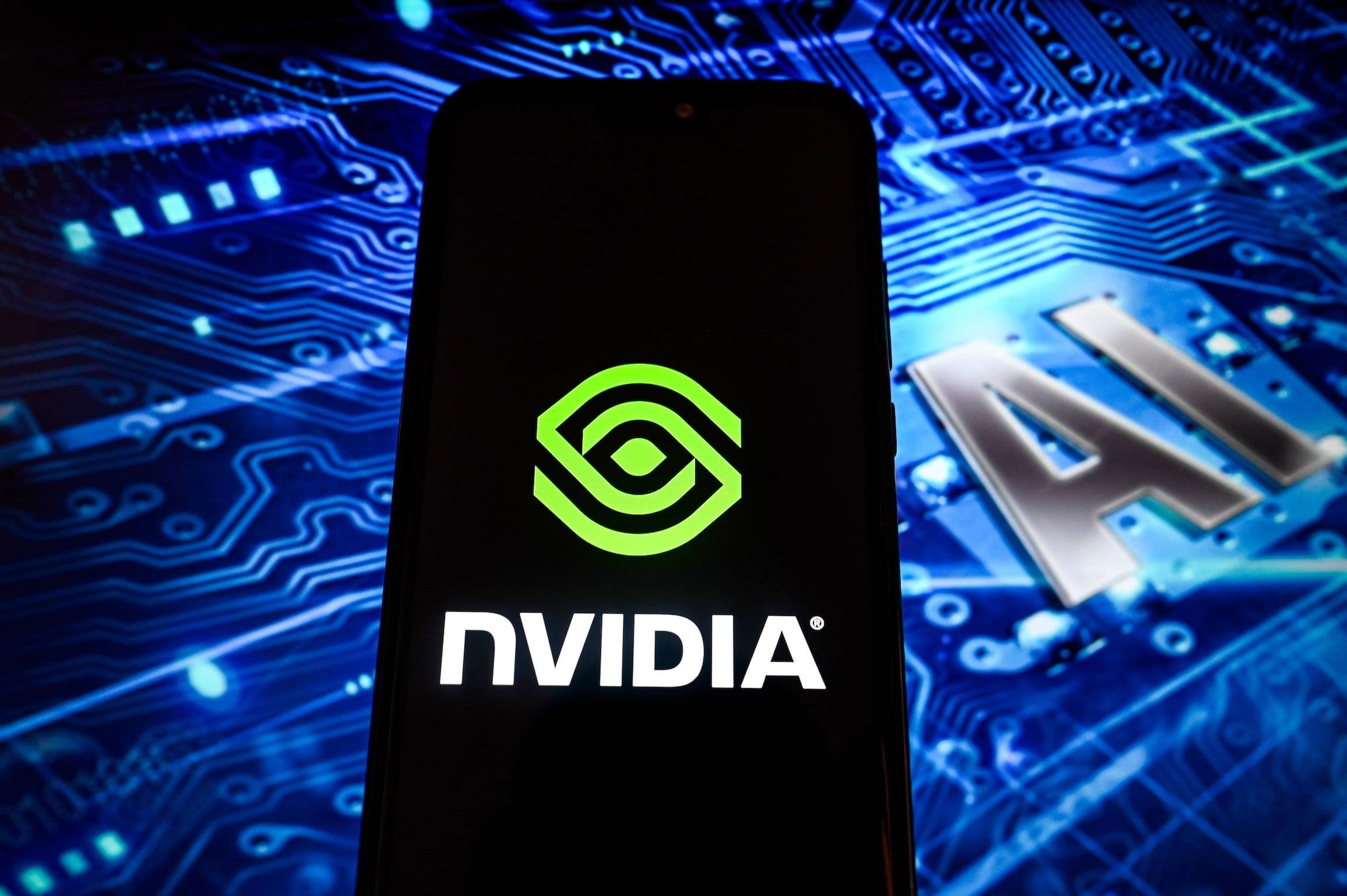 Technology China: Das Bild zeigt ein Smartphone, auf dem das NVIDIA Logo zu sehen ist, im Hintergrund eine Halbleiterplatte, auf der AI zu lesen ist - Artificial Intelligence, Künstliche Intelligenz