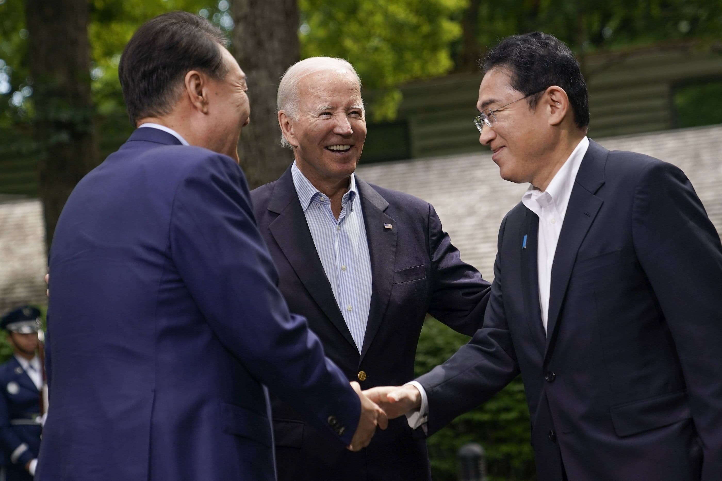 US-Präsident Joe Biden lächelt, während sich der südkoreanische Präsident Yoon Suk Yeol und der japanische Premierminister Fumio Kishida die Hand geben