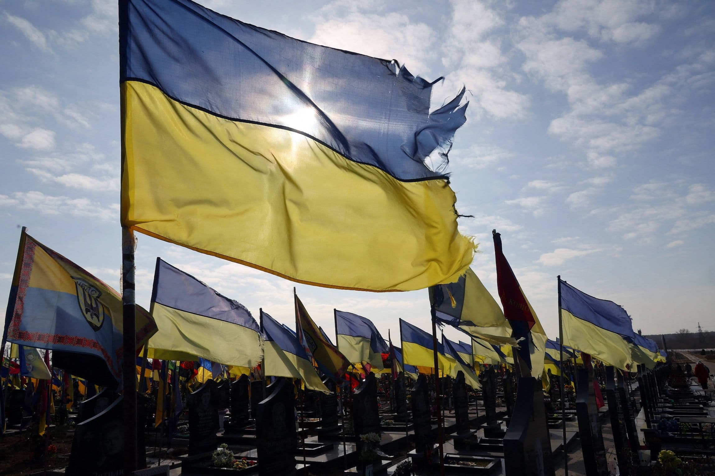 Witterungsbedingte ukrainische Flaggen flattern im Wind an den Gräbern der im russisch-ukrainischen Krieg gefallenen Militärangehörigen auf einem Soldatenfriedhof in Charkiw im Nordosten der Ukraine